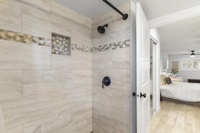 ensuite bathroom featuring wood finished floors, tiled shower, ensuite bath, and a ceiling fan