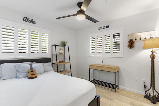 bedroom featuring ceiling fan, light wood finished floors, and baseboards