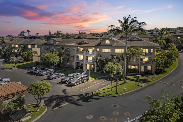 property at dusk featuring uncovered parking and a residential view