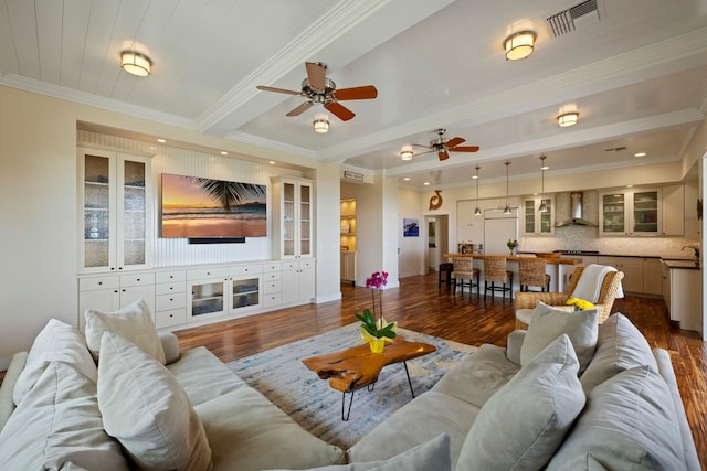 living area featuring crown molding, ceiling fan, dark wood-style floors, and visible vents