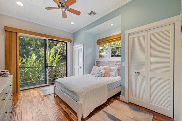 bedroom featuring ceiling fan, multiple windows, light hardwood / wood-style floors, and access to exterior