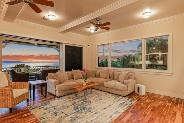 living area with baseboards, wood finished floors, crown molding, and ceiling fan