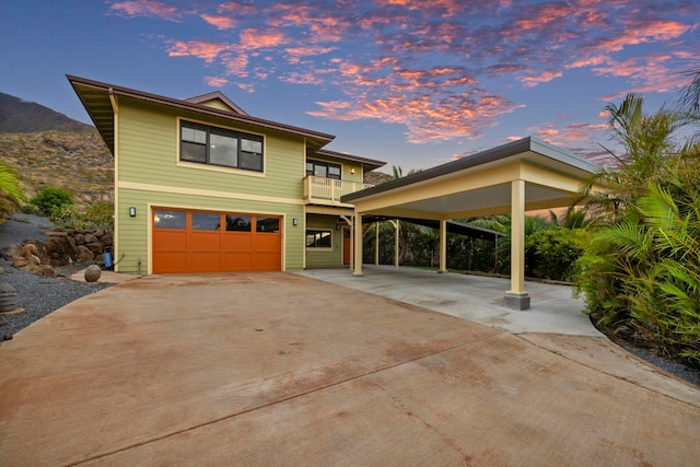 view of front of house with an attached garage, driveway, and a balcony