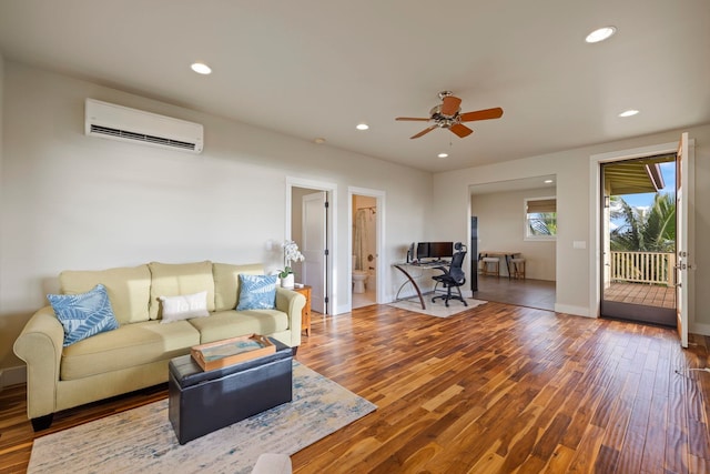 living area featuring a ceiling fan, wood finished floors, an AC wall unit, and recessed lighting