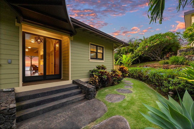 exterior entry at dusk with a lawn