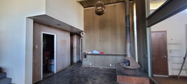 corridor featuring wood walls and a towering ceiling