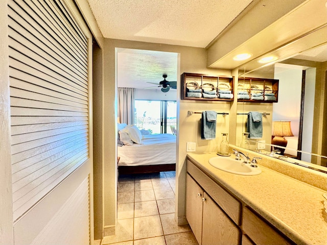 bathroom with vanity, ceiling fan, a textured ceiling, and tile patterned floors