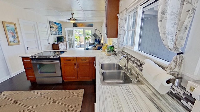 kitchen featuring stainless steel range with electric stovetop, kitchen peninsula, ceiling fan, dark wood-type flooring, and sink