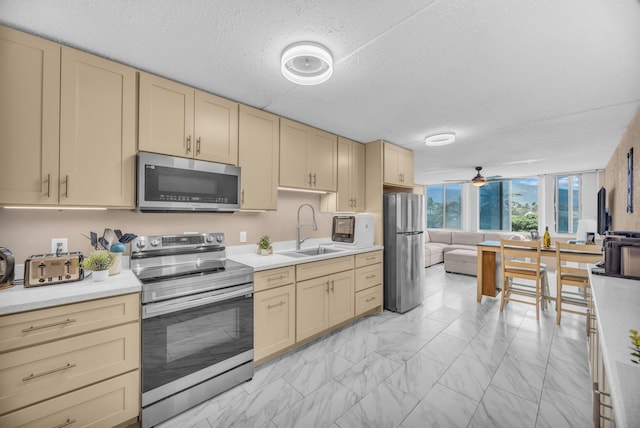 111 Kahului Beach Rd Unit D402, Kahului, HI 96732 - kitchen featuring appliances with stainless steel finishes, a sink, light marble finish flooring, light countertops, and ceiling fan