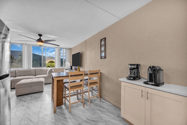 111 Kahului Beach Rd Unit D402, Kahului, HI 96732 - living area with a textured wall, a ceiling fan, and light marble finish flooring