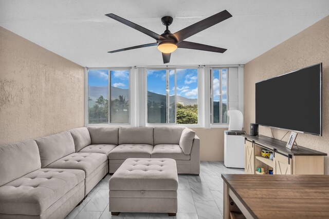 111 Kahului Beach Rd Unit D402, Kahului, HI 96732 - living room with a textured wall, a ceiling fan, and light marble finish floors
