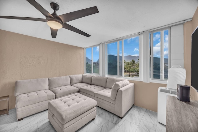 111 Kahului Beach Rd Unit D402, Kahului, HI 96732 - living area with a ceiling fan, light marble finish flooring, and a textured wall