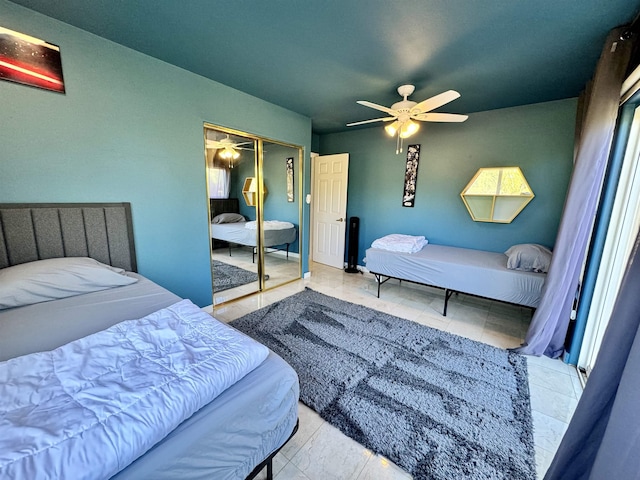 bedroom featuring light tile patterned flooring, ceiling fan, and a closet