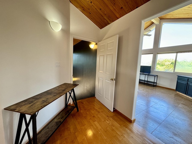 hallway featuring wooden ceiling, light wood-type flooring, and vaulted ceiling