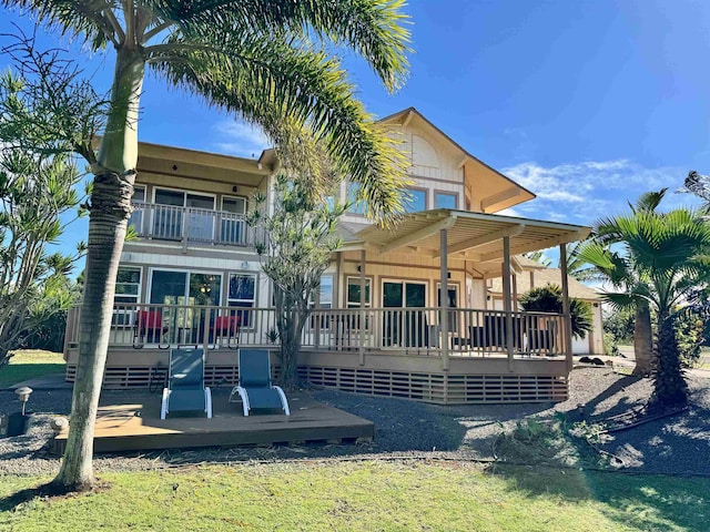 rear view of house featuring a balcony and a deck