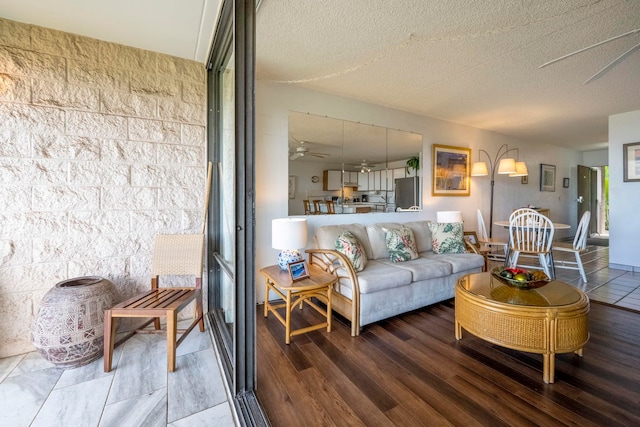 living room with ceiling fan, hardwood / wood-style floors, and a textured ceiling