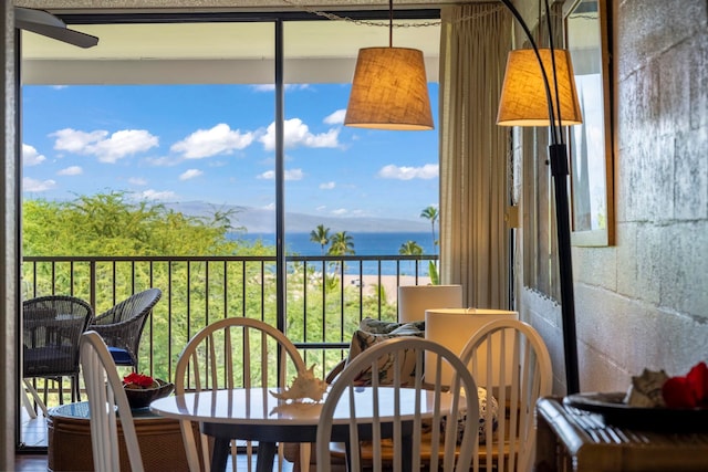 sunroom featuring a water view and ceiling fan