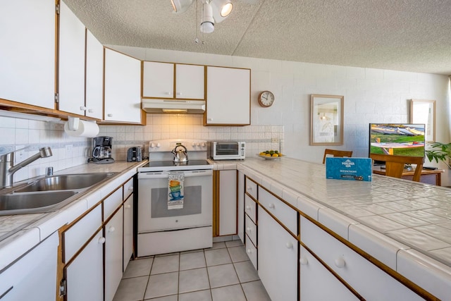 kitchen featuring electric range, sink, a textured ceiling, and white cabinetry