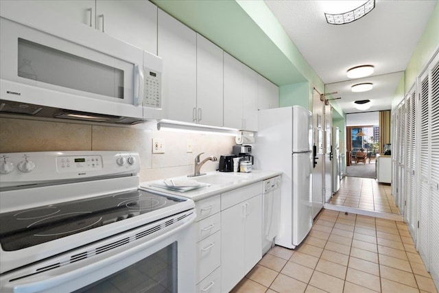 45 Kai Ala Dr Unit A409, Lahaina, HI 96761 - kitchen featuring white appliances, a sink, light tile patterned flooring, white cabinetry, and light countertops