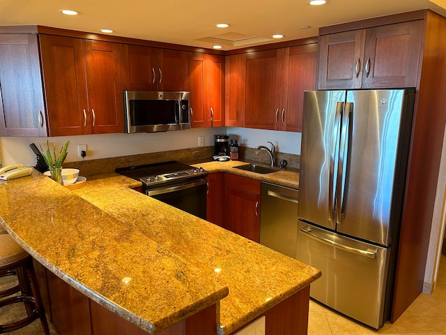 kitchen featuring kitchen peninsula, light stone counters, stainless steel appliances, sink, and light tile patterned floors