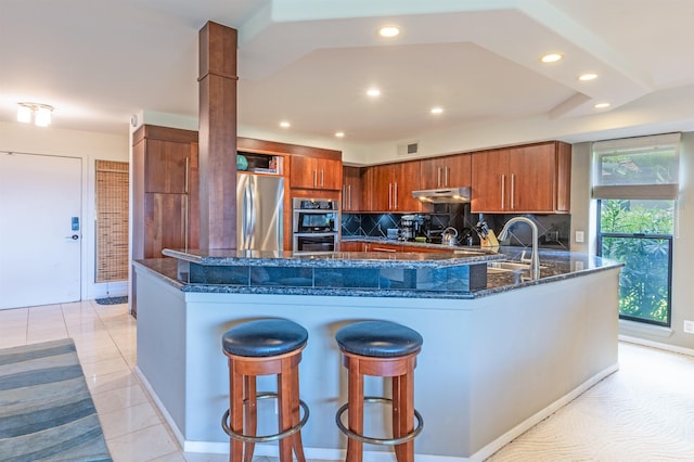 150 Puukolii Rd Unit 18, Lahaina, HI 96761 - kitchen with stainless steel appliances, brown cabinetry, recessed lighting, dark stone countertops, and tasteful backsplash