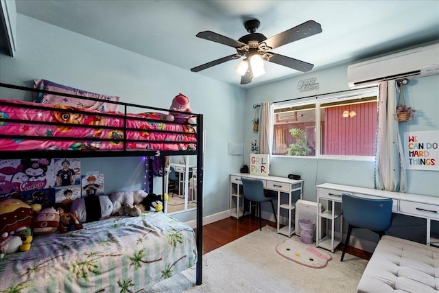 980 Kuhio Pl, Wailuku, HI 96793 - bedroom featuring an office area, wood finished floors, an AC wall unit, a ceiling fan, and baseboards
