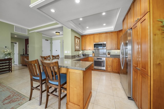 kitchen with stainless steel appliances, kitchen peninsula, dark stone counters, a kitchen bar, and light tile patterned floors