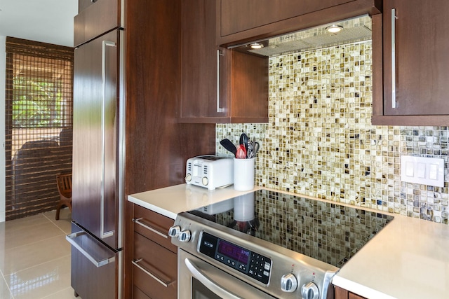 kitchen featuring decorative backsplash, light tile patterned flooring, and appliances with stainless steel finishes