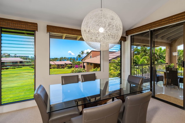 carpeted dining room featuring lofted ceiling