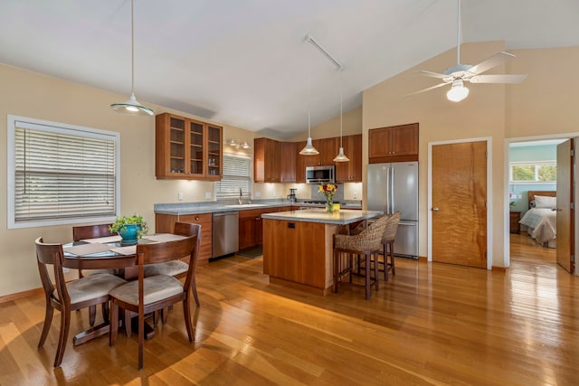 50 Uakoko Pl, Haiku, HI 96708 - kitchen with appliances with stainless steel finishes, brown cabinetry, light wood finished floors, a kitchen bar, and a center island