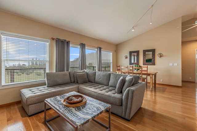 living room with light hardwood / wood-style floors and vaulted ceiling