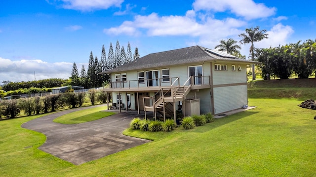 rear view of property featuring a wooden deck, a yard, and a patio