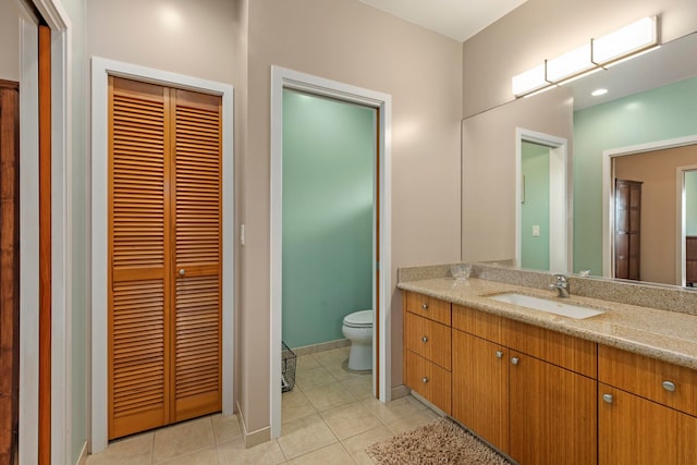 bathroom featuring tile patterned flooring, vanity, and toilet