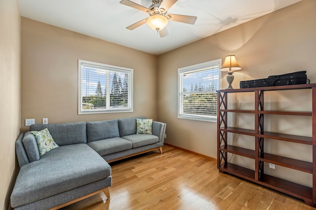 living room with light hardwood / wood-style flooring and ceiling fan