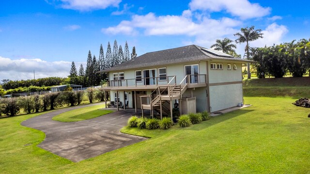 50 Uakoko Pl, Haiku, HI 96708 - back of house with asphalt driveway, a yard, a wooden deck, stairs, and roof mounted solar panels