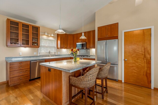 50 Uakoko Pl, Haiku, HI 96708 - kitchen featuring appliances with stainless steel finishes, a sink, light wood finished floors, brown cabinets, and high vaulted ceiling