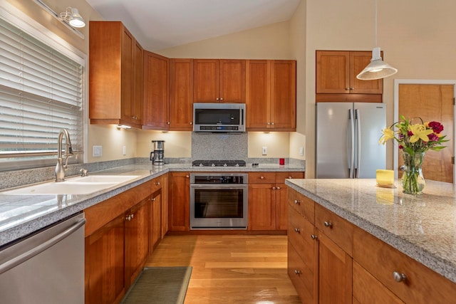 50 Uakoko Pl, Haiku, HI 96708 - kitchen featuring appliances with stainless steel finishes, a sink, light wood-style floors, light countertops, and brown cabinets
