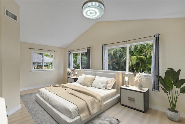 bedroom featuring light hardwood / wood-style floors and lofted ceiling