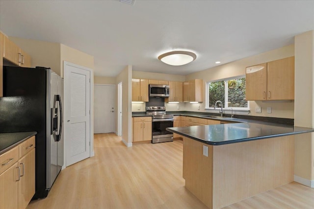 kitchen featuring kitchen peninsula, light brown cabinets, stainless steel appliances, and light hardwood / wood-style floors