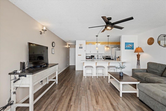 1993 S Kihei Rd Unit 308, Kihei, HI 96753 - living room featuring dark wood-style flooring, a ceiling fan, a textured ceiling, and baseboards