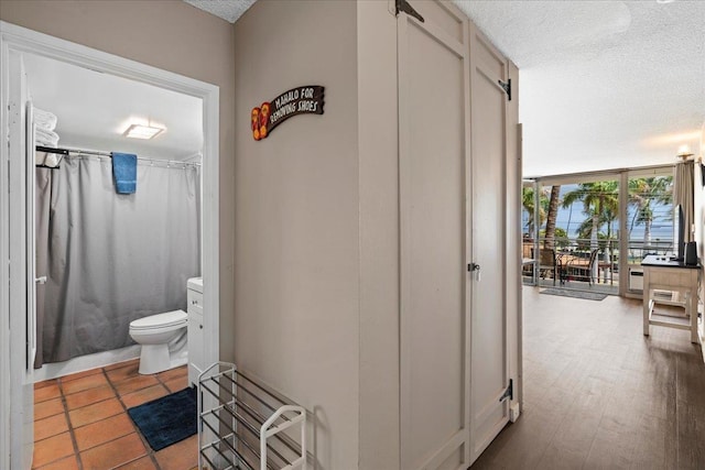 1993 S Kihei Rd Unit 308, Kihei, HI 96753 - full bathroom featuring a textured ceiling, toilet, a wall of windows, and a shower with curtain