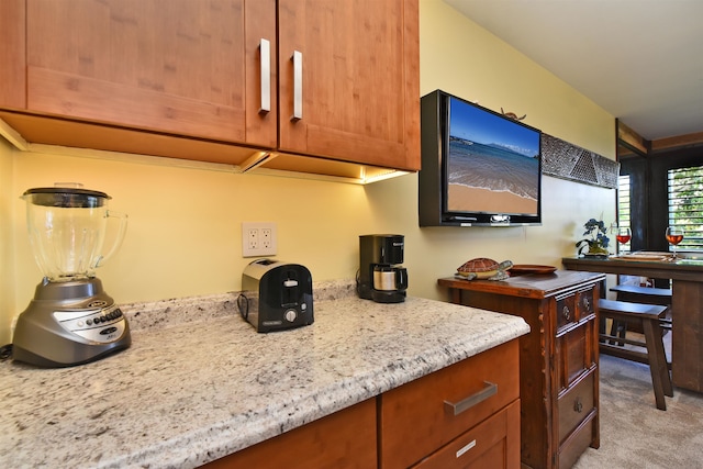 kitchen featuring light carpet and light stone counters