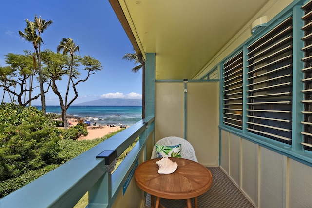 balcony featuring a beach view and a water view