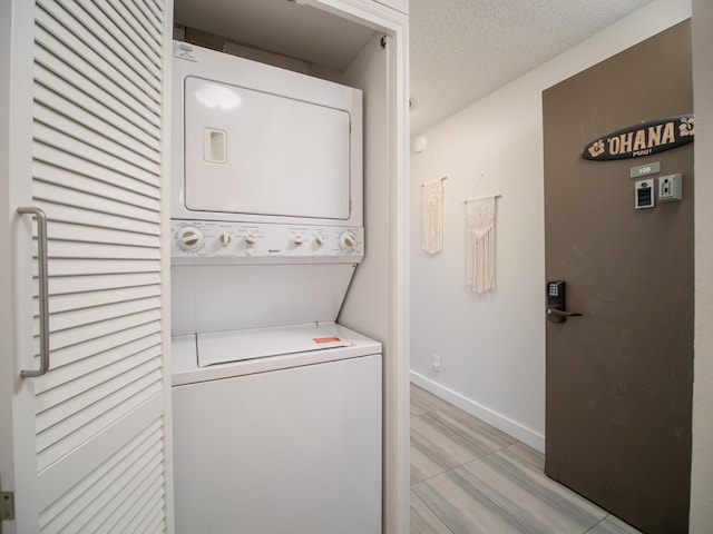 laundry room with a textured ceiling and stacked washer and dryer