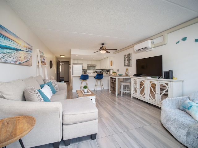 living room featuring a textured ceiling, light hardwood / wood-style floors, a wall mounted AC, and ceiling fan