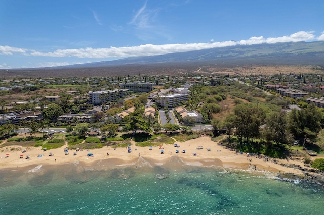 drone / aerial view featuring a view of the beach and a water and mountain view