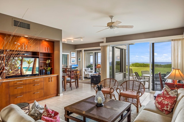 living room featuring a wealth of natural light, ceiling fan, and light tile patterned floors