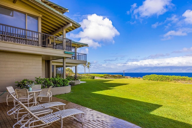 view of yard with a balcony, a water view, and a patio area