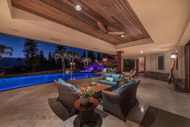 patio at night with outdoor lounge area and ceiling fan