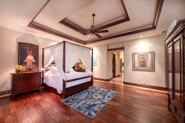 bedroom with a raised ceiling, ceiling fan, crown molding, and hardwood / wood-style flooring